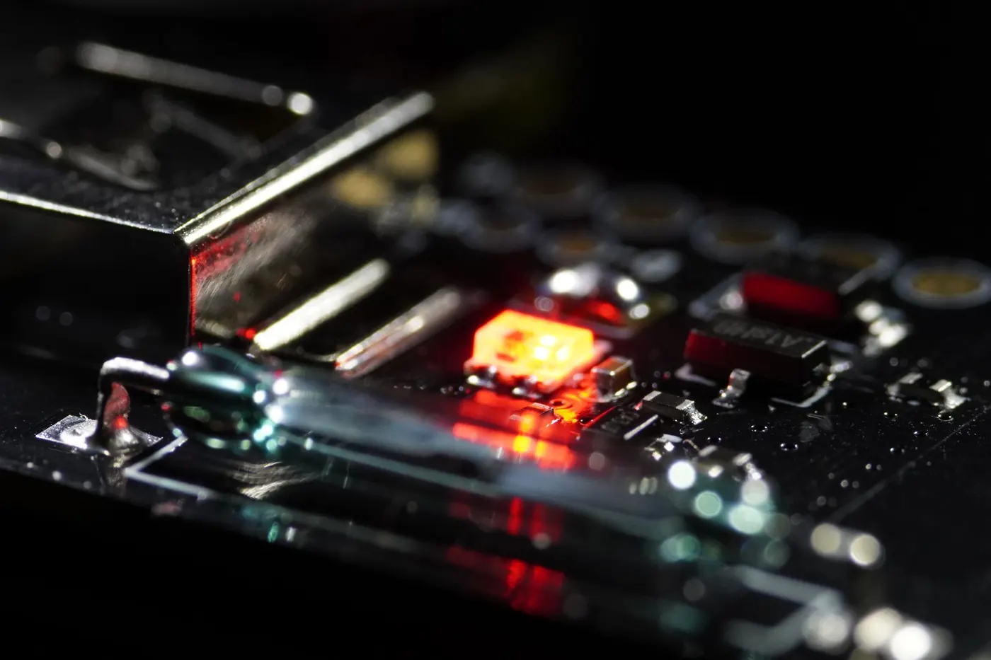 Macro of an OBJEX board in the dark with a single red LED lit