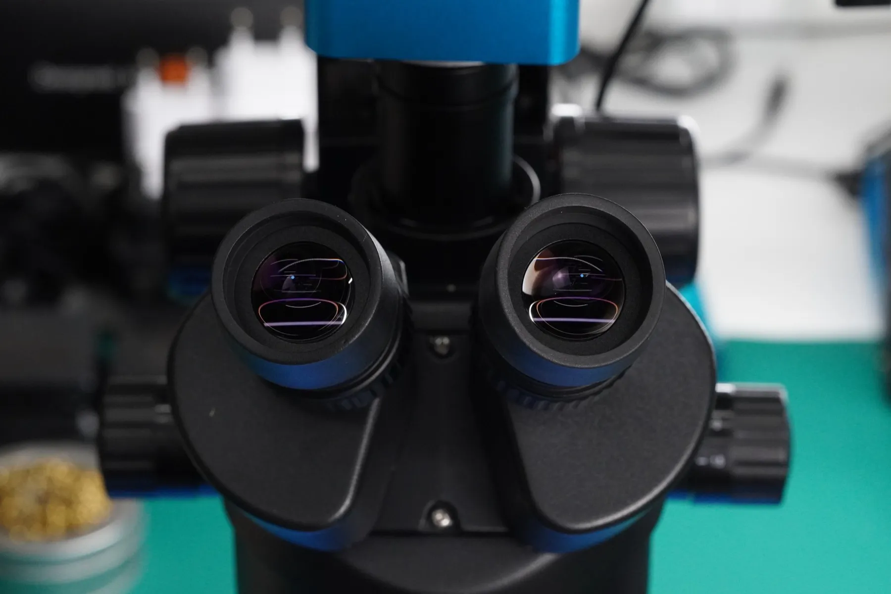 Trinocular inspection microscope with a camera on top, on a teal bench mat in the OBJEX lab