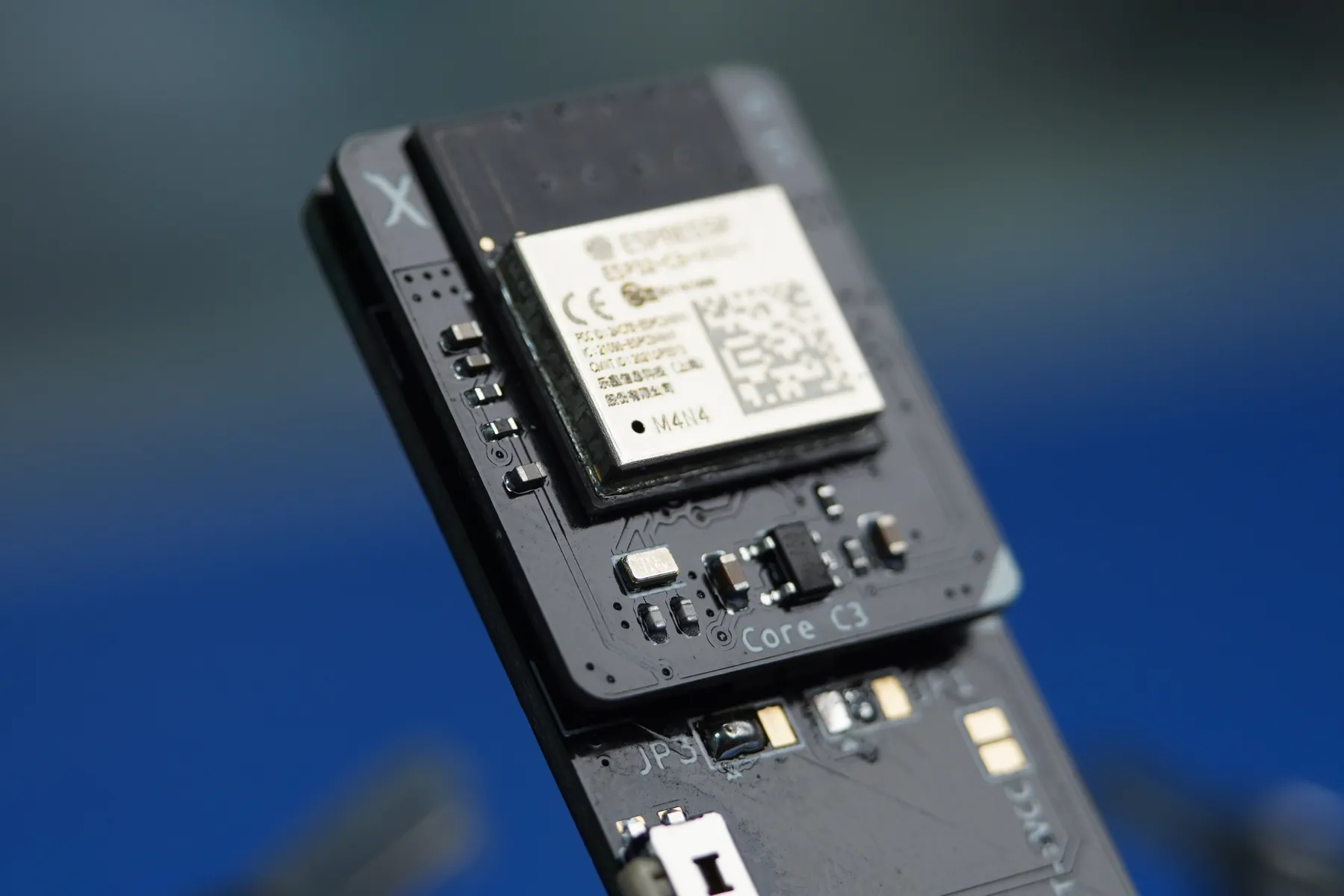 Macro of an OBJEX Core C3 board, the shielded Espressif ESP32-C3 module in focus above the silkscreen reading Core C3