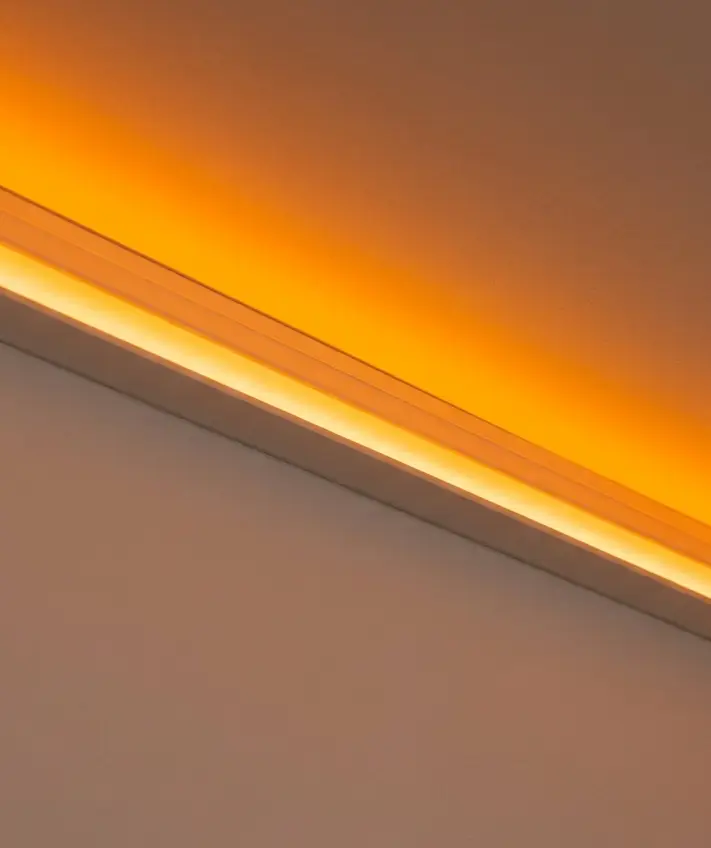 An amber LED strip glowing in a ceiling profile