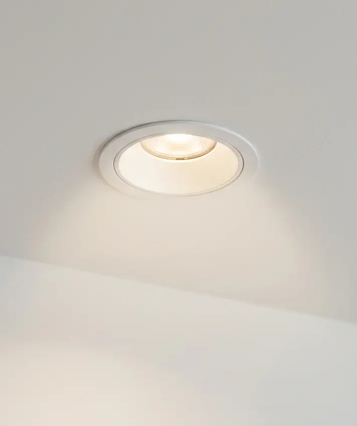 A white recessed LED spot in a ceiling